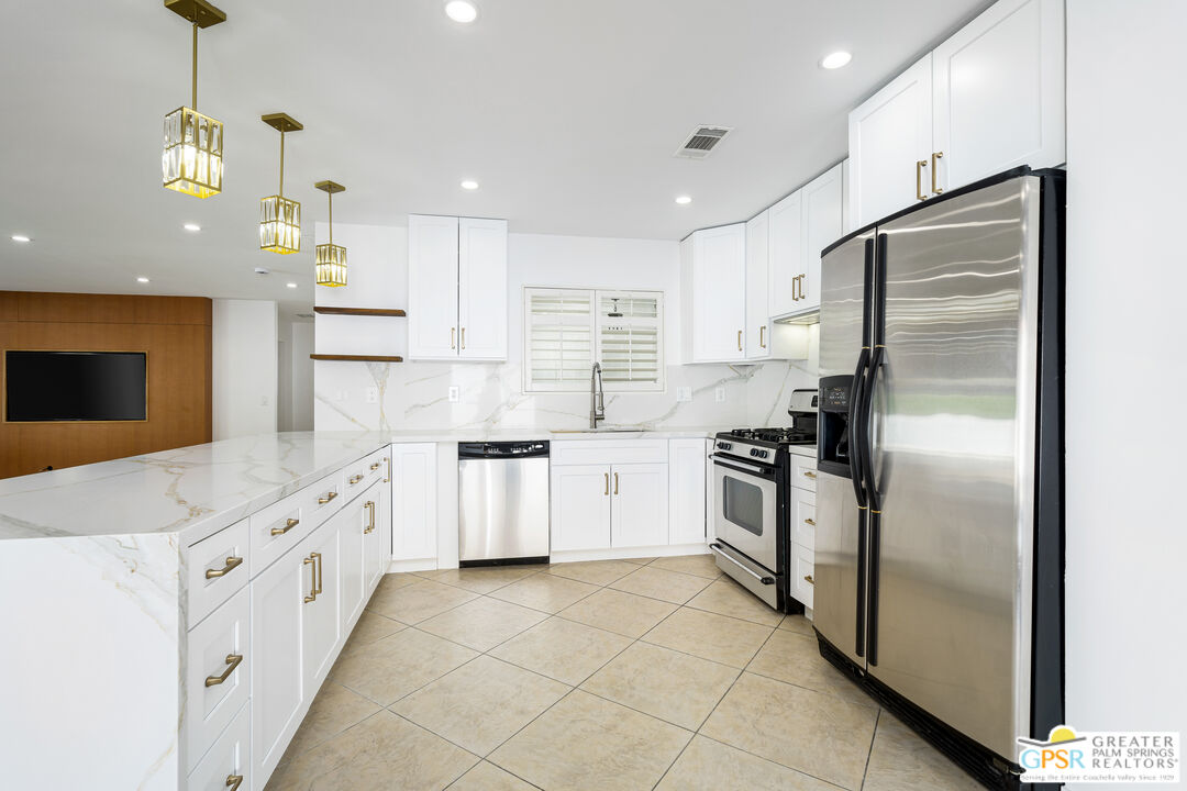 2750 East Vincentia Road Palm Springs, CA 92262 - Photo 25 of 55 a kitchen with stainless steel appliances kitchen island granite countertop a refrigerator a oven a sink and a refrigerator