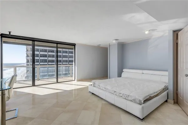 a bedroom with a large bed and a large window