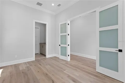 an empty room with wooden floor & windows
