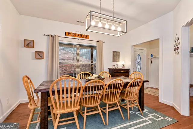 a view of a dining room and livingroom with furniture a chandelier and wooden floor