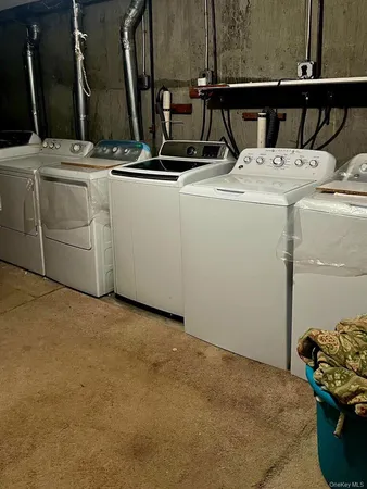a view of storage and utility room with two washing machine