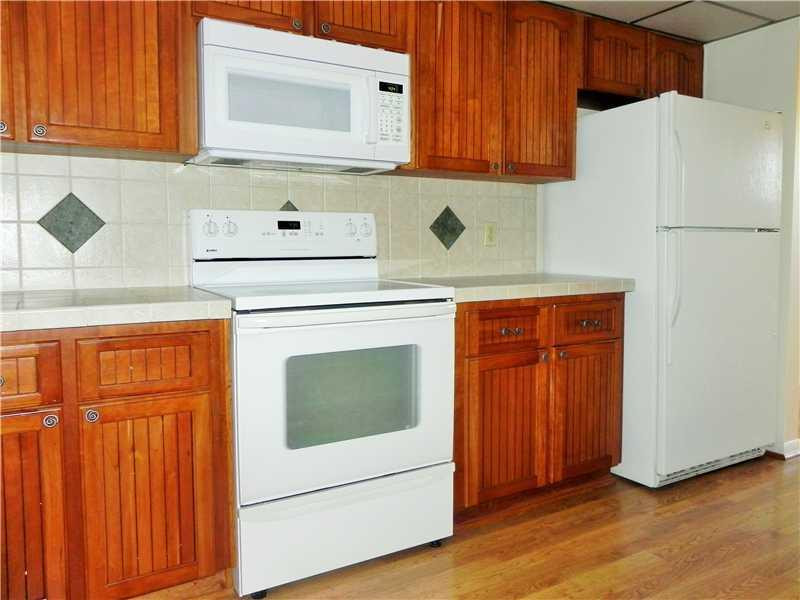 4183 Southwest 87th Terrace, Unit 4183 Davie, FL 33328 - Photo 11 of 34 a kitchen with stainless steel appliances wooden cabinets and a sink