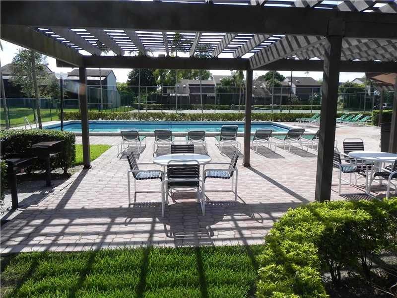 4183 Southwest 87th Terrace, Unit 4183 Davie, FL 33328 - Photo 30 of 34 a view of a patio with a table chairs and a backyard