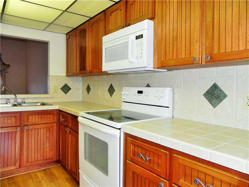 4183 Southwest 87th Terrace, Unit 4183 Davie, FL 33328 - Photo 10 of 34 a kitchen with stainless steel appliances granite countertop a sink dishwasher stove and cabinets with wooden floor
