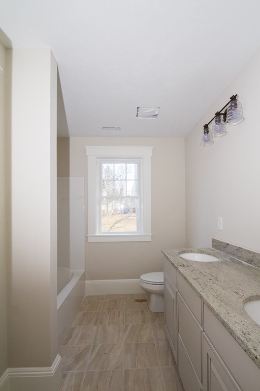 27 Birch Road Littleton, MA 01460 - Photo 20 of 22 a bathroom with a granite countertop sink a toilet and a window