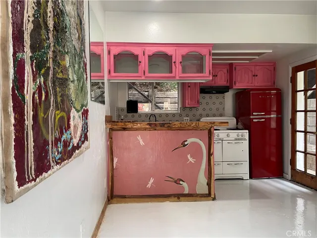 a utility room with stainless steel appliances granite countertop a stove and cabinets