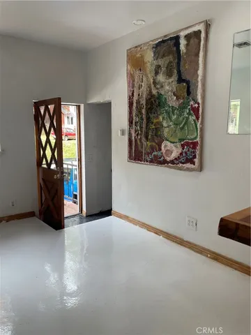 an empty room with painting and furniture