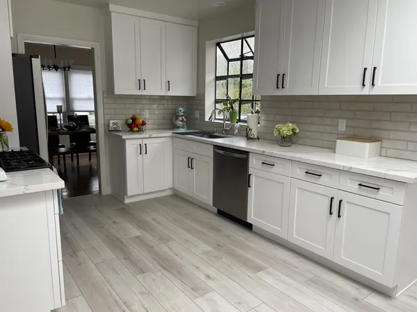 a kitchen with cabinets appliances a sink and a window