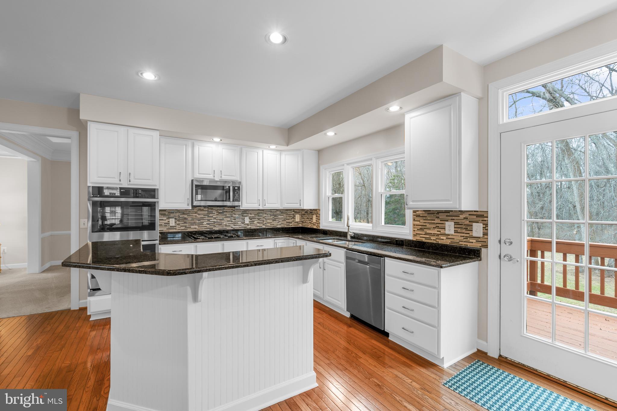 4615 Brightwood Road Olney, MD 20832 - Photo 12 of 45 a kitchen with stainless steel appliances granite countertop a stove a sink and a microwave