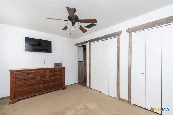 a bedroom with a bed a flat screen tv and a window