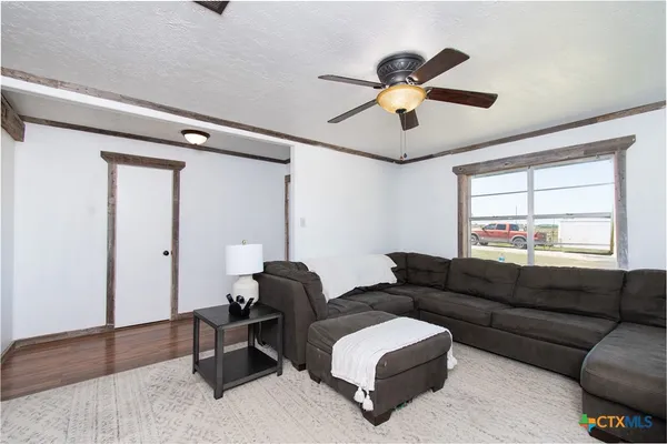 a view of a livingroom with wooden floor and a ceiling fan