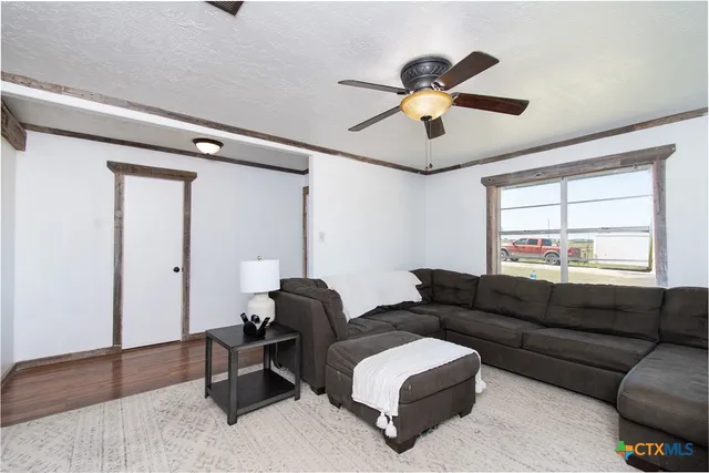 a view of a livingroom with wooden floor and a ceiling fan