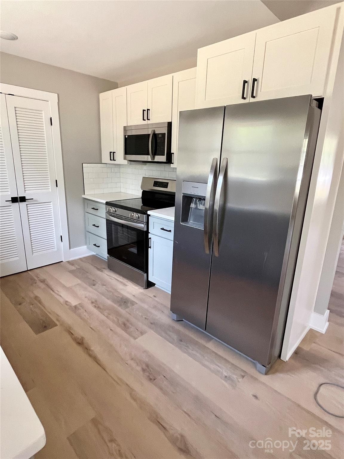 6255 Old Salisbury Road Linwood, NC 27299 - Photo 8 of 21 a kitchen with kitchen island a counter top space a sink stainless steel appliances and cabinets