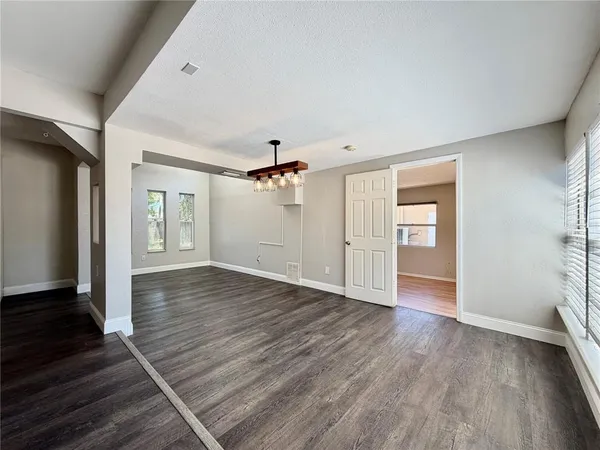 a view of a livingroom with wooden floor and a ceiling fan