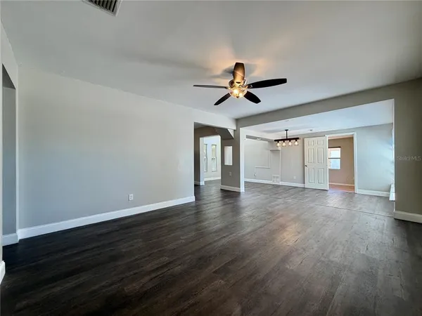 a view of a room with wooden floor and ceiling fan