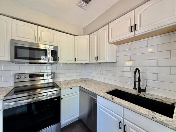 a kitchen with a sink stove and microwave