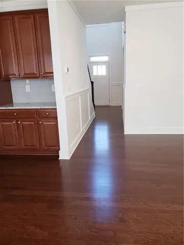 a view of a kitchen with wooden floor and cabinets