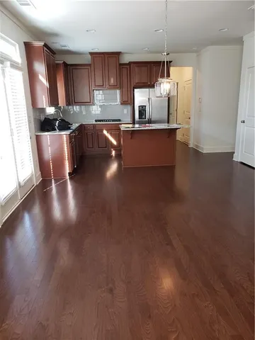 a kitchen with granite countertop a stove and a wooden floors
