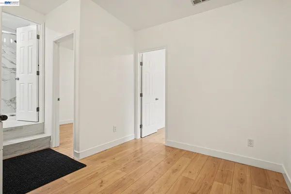 a view of empty room with wooden floor