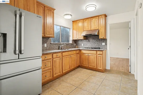 a kitchen with a refrigerator sink and cabinets