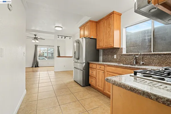 a kitchen with stainless steel appliances granite countertop a stove a sink and a refrigerator