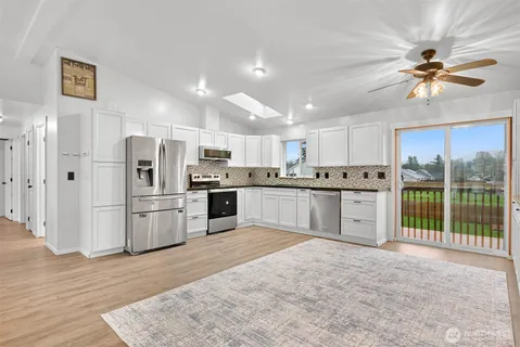 a view of a room with a ceiling fan and window
