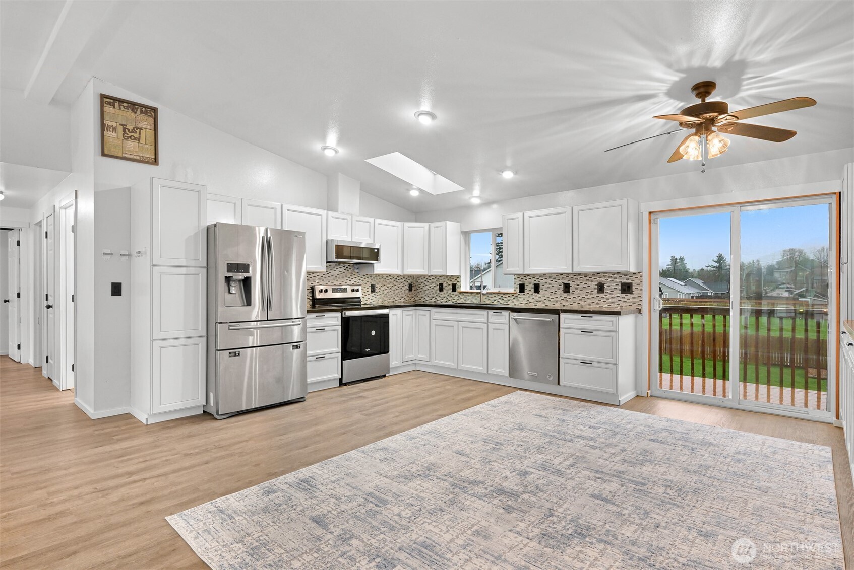 512 Allison Way Nooksack, WA 98276 - Photo 14 of 37 a kitchen with stainless steel appliances kitchen island granite countertop a refrigerator oven a sink with dishwasher a stove and white cabinets with wooden floor