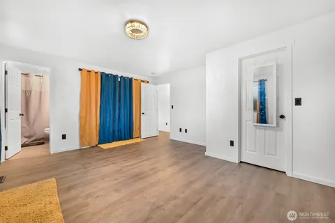 an empty room with windows and a ceiling fan