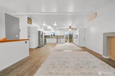 a kitchen with stainless steel appliances granite countertop a refrigerator stove a sink and white cabinets