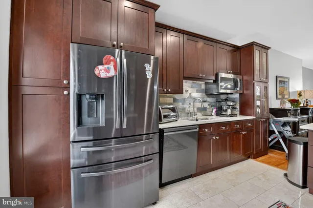 a kitchen with stainless steel appliances granite countertop a refrigerator and a stove