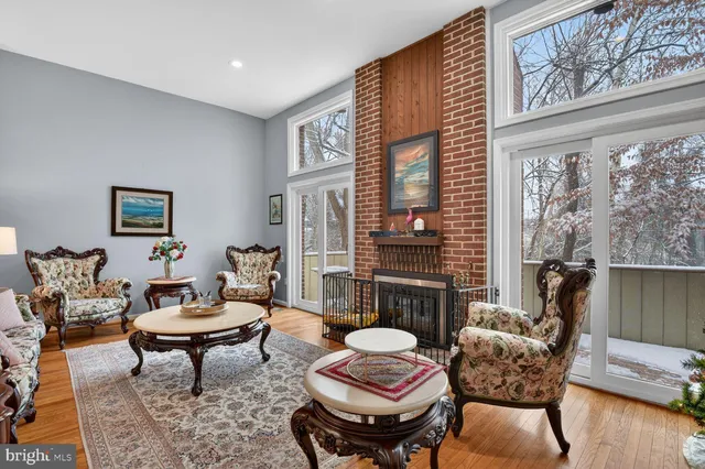 a living room with furniture a fireplace and wooden floor