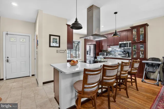 a kitchen with stainless steel appliances a dining table chairs and white cabinets