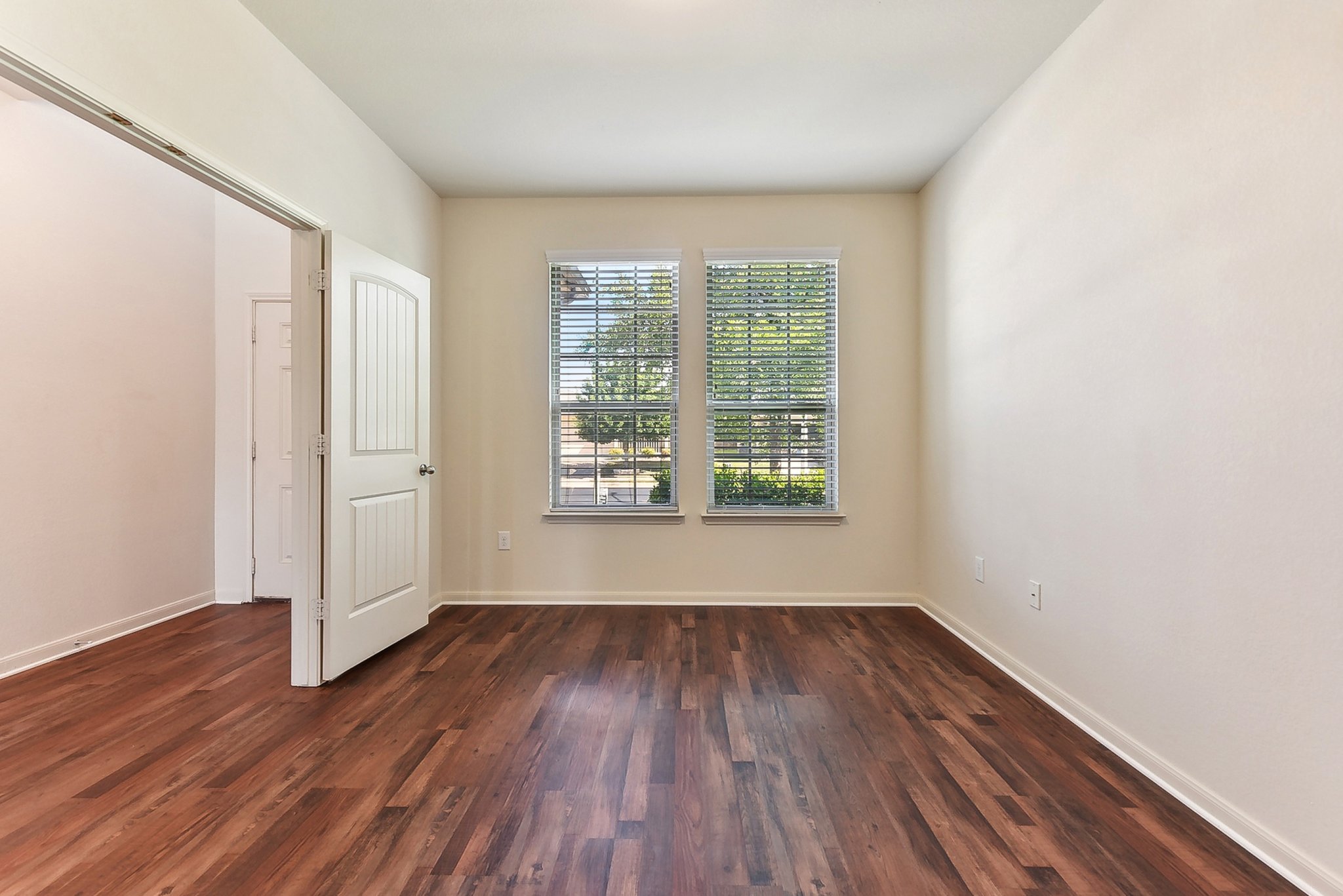 310 Potters Peak Way Georgetown, TX 78626 - Photo 8 of 21 Spacious room featuring rich wood-finish flooring, ample natural light from two windows with blinds, high ceilings, and an interior panel door