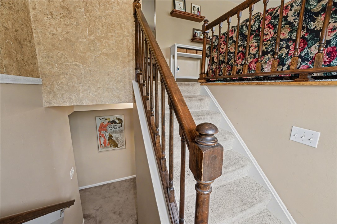4919 Silver Arrow Drive Riverside, OH 45424 - Photo 6 of 57 This interior staircase offers seamless transitions between levels with carpeted steps and wooden railings.