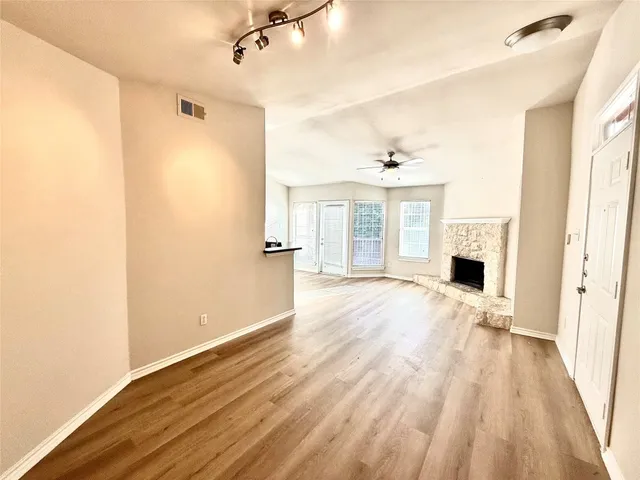 a view of empty room with wooden floor and fireplace