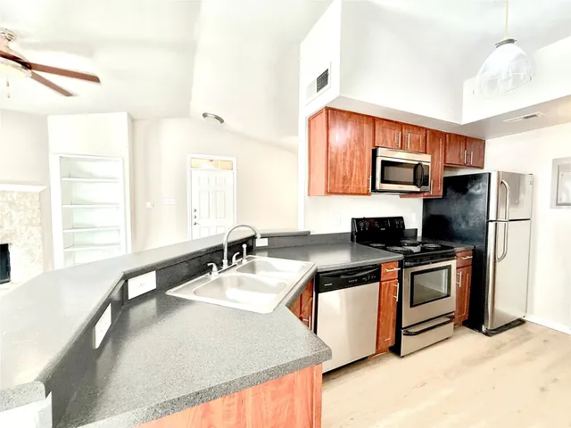 a kitchen with kitchen island a sink stainless steel appliances and window