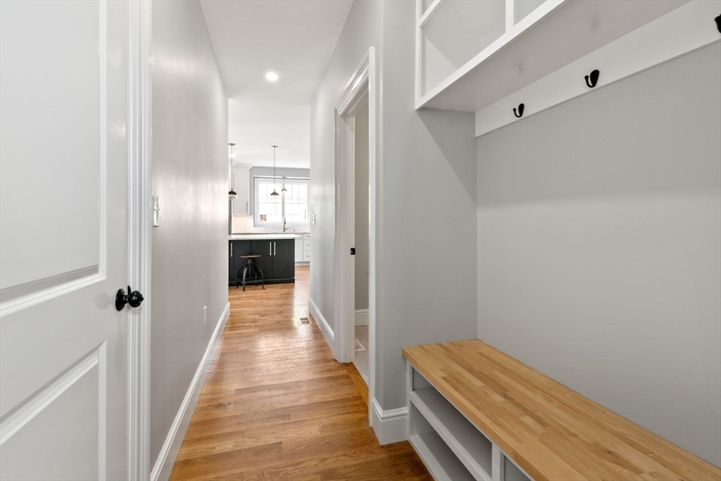 9 Adams Lane, Unit 9 Sherborn, MA 01770 - Photo 11 of 26 a view of a hallway with wooden floor and staircase