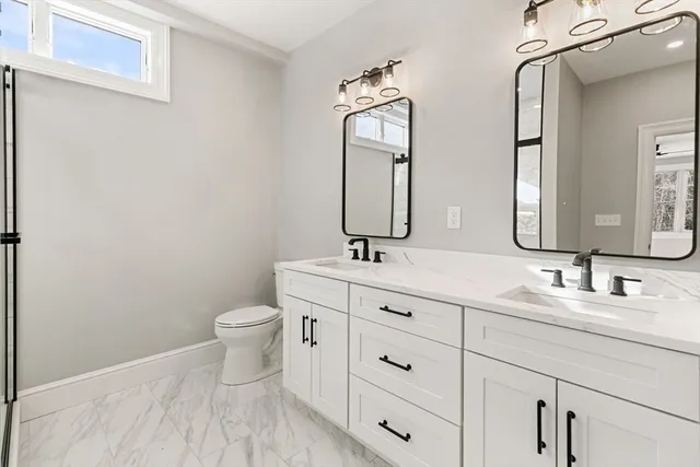 a bathroom with a toilet sink and mirror