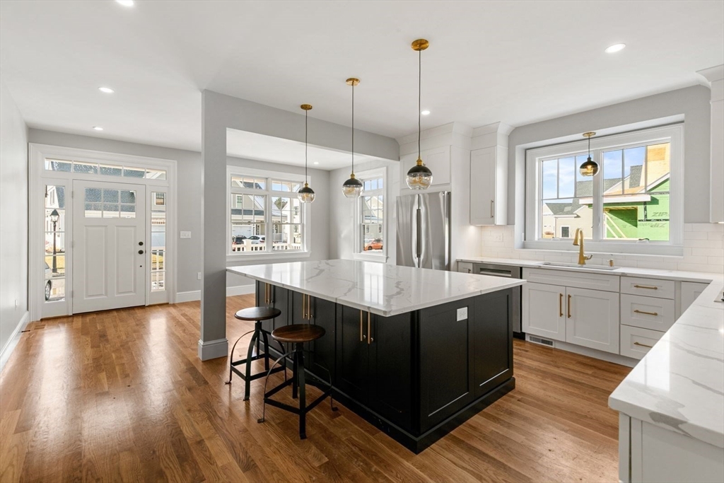 9 Adams Lane, Unit 9 Sherborn, MA 01770 - Photo 3 of 26 a kitchen with stainless steel appliances granite countertop a sink a stove a refrigerator and wooden floor