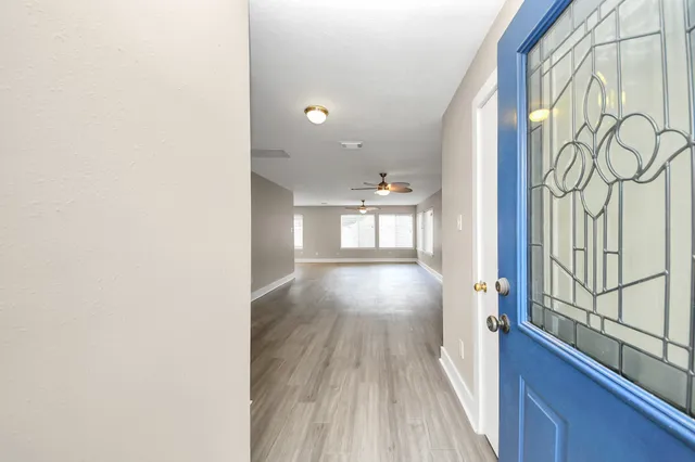 a view of hallway with wooden floor and fence
