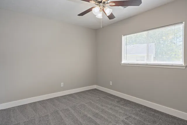 an empty room with closet and a chandelier fan