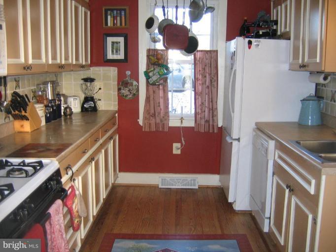 3808 Beckleysville Road Hampstead, MD 21074 - Photo 12 of 28 a kitchen with stainless steel appliances granite countertop a refrigerator a stove and a sink with wooden floor