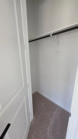 an empty room with a ceiling fan and closet area