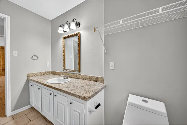 a bathroom with a granite countertop sink and a mirror
