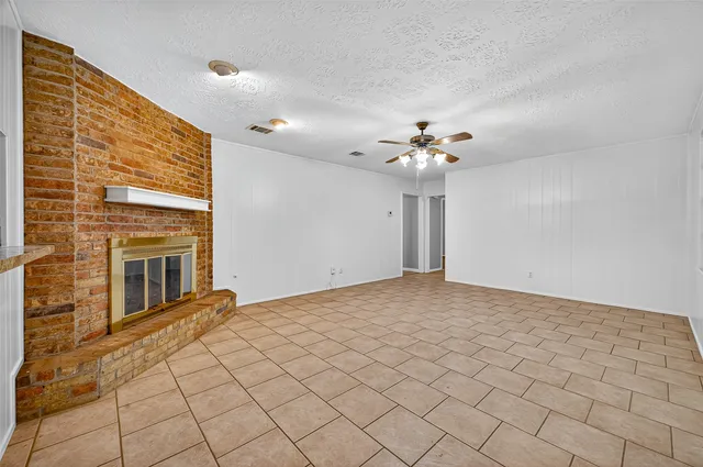 a view of a livingroom with a chandelier fan and window