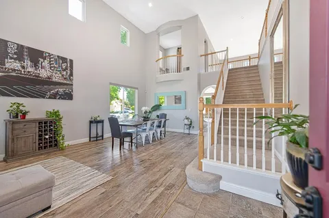 a dining room with wooden floor and a potted plant