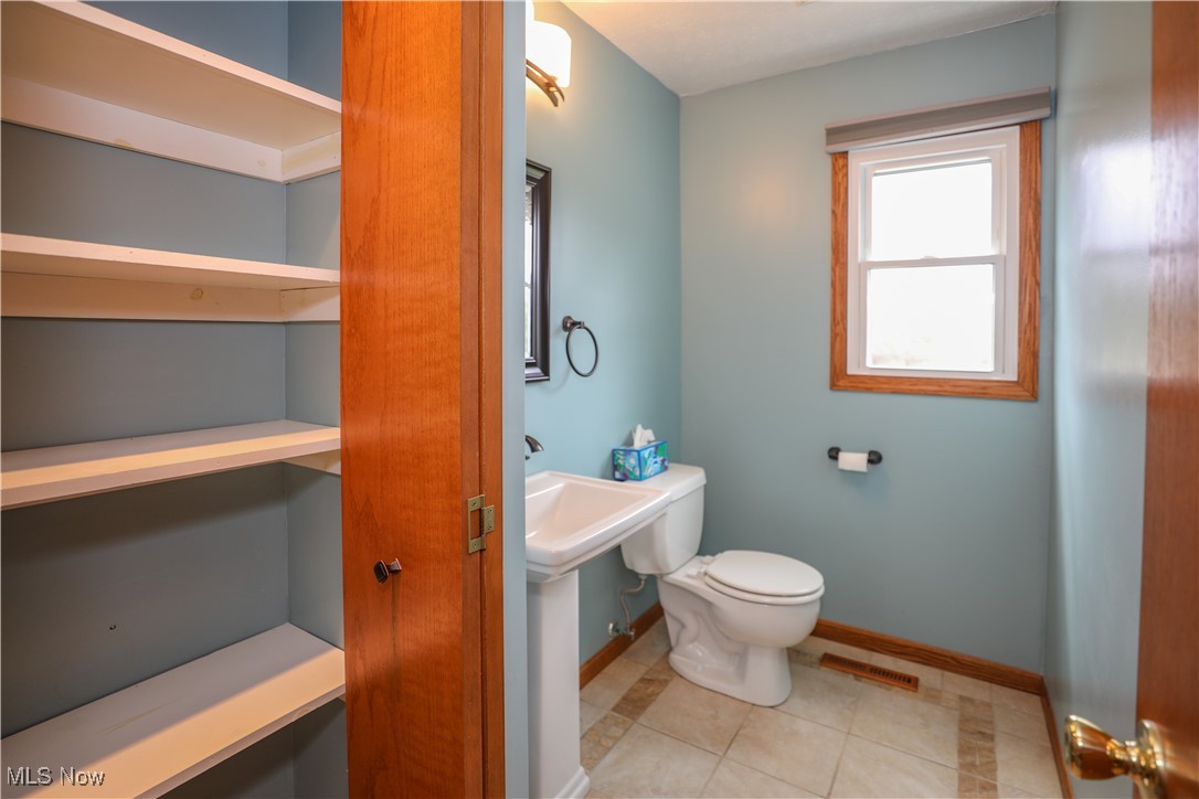12565 Alpha Road Hiram, OH 44234 - Photo 20 of 50 Half bath with tile patterned flooring, toilet, visible vents, and baseboards