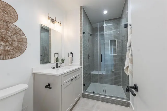 a bathroom with a sink a toilet and shower