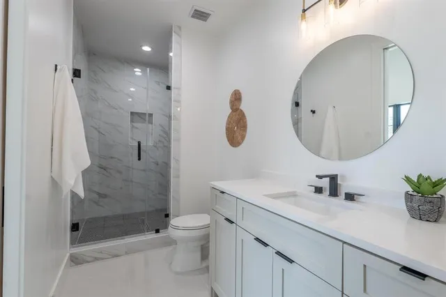 a bathroom with a sink a toilet and shower
