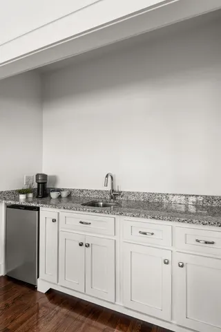 a bathroom with a granite countertop sink a mirror and shower